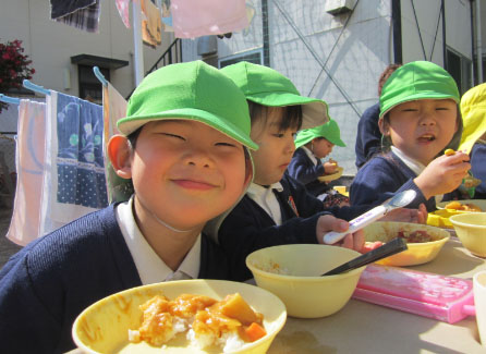 野外昼食会での笑顔の園児の写真
