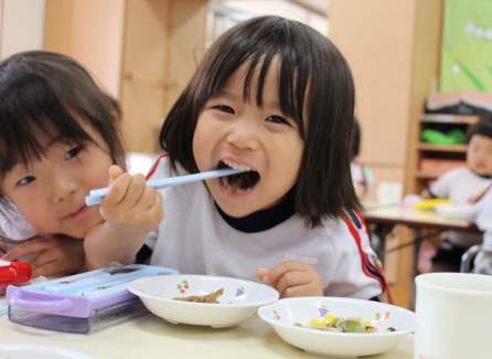 笑顔で食事をしている園児たちの写真